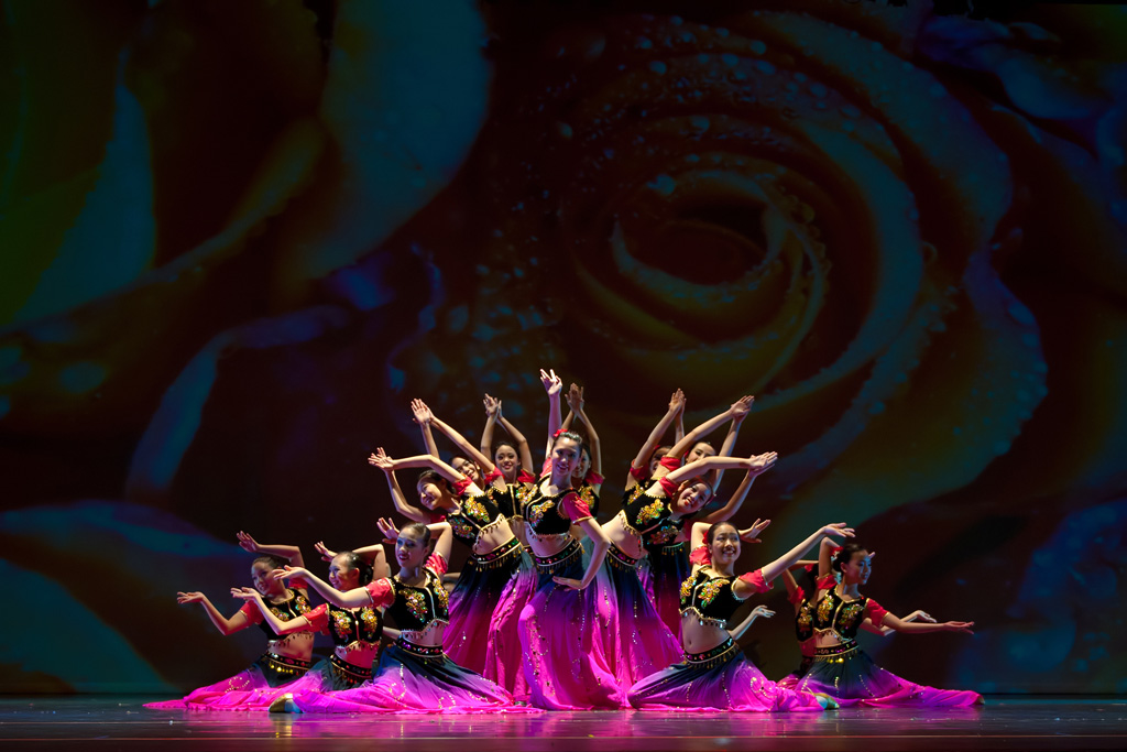 Black and white photo of a women performing modern dance on a dark background.